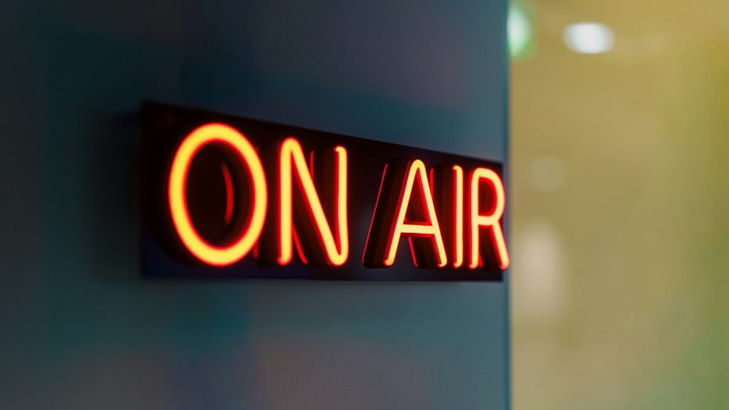 red neon on-air sign glowing on a wall