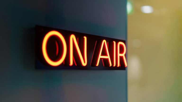 red neon on-air sign glowing on a wall