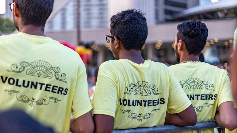 three men wearing yellow volunteer shirts