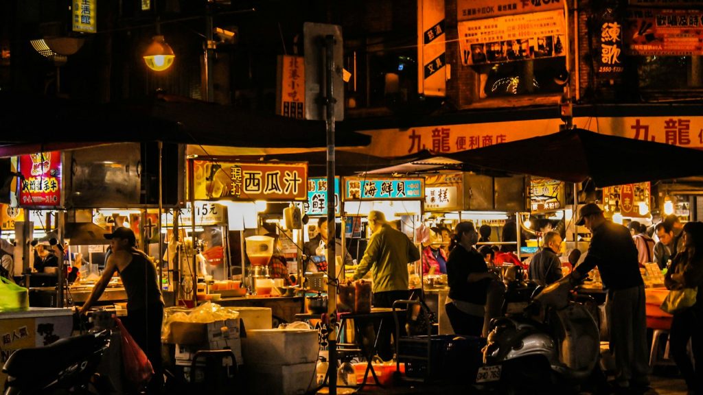 people eating street food at a night market
